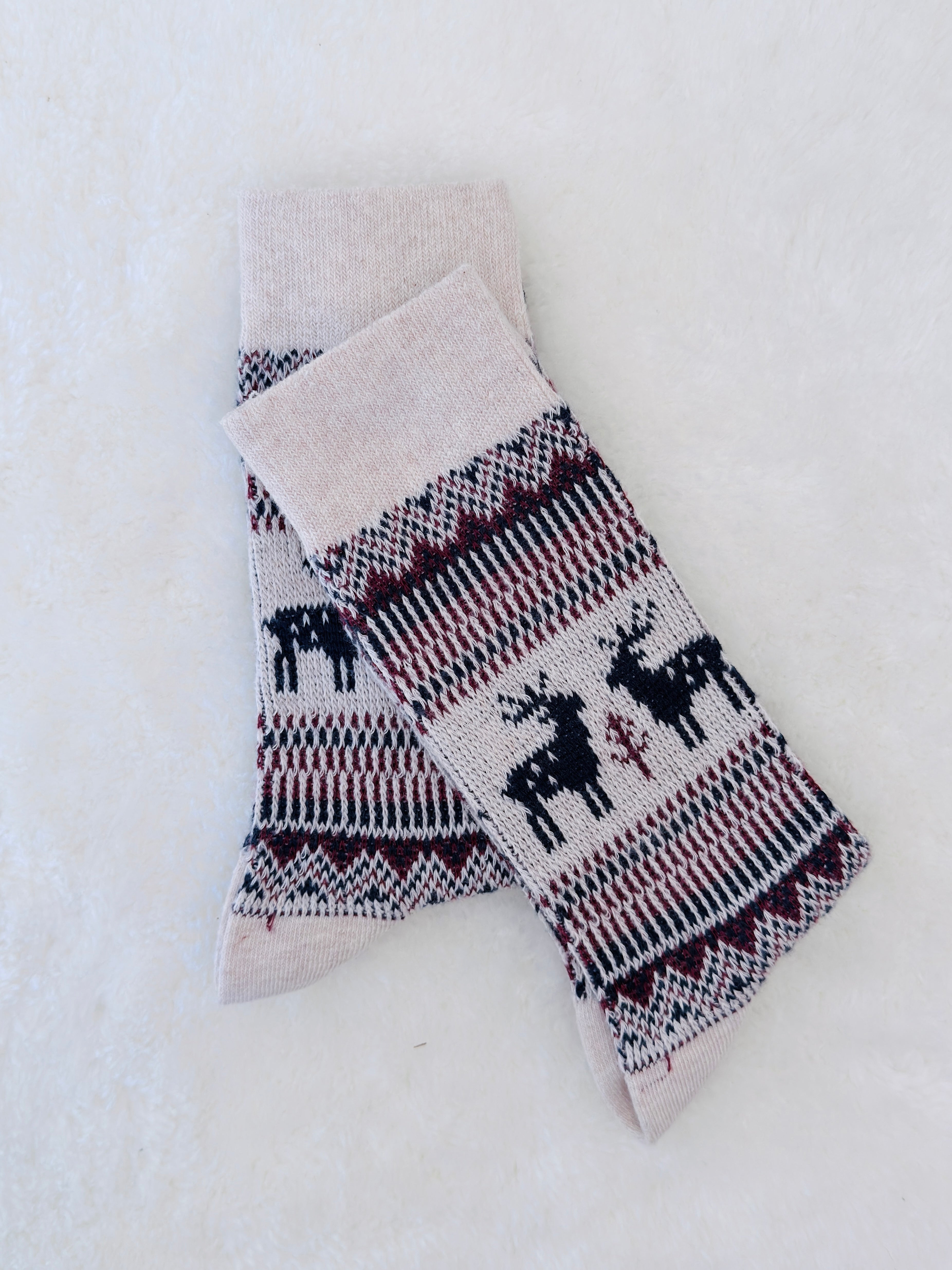 Knitted socks with reindeer pattern on a white background
