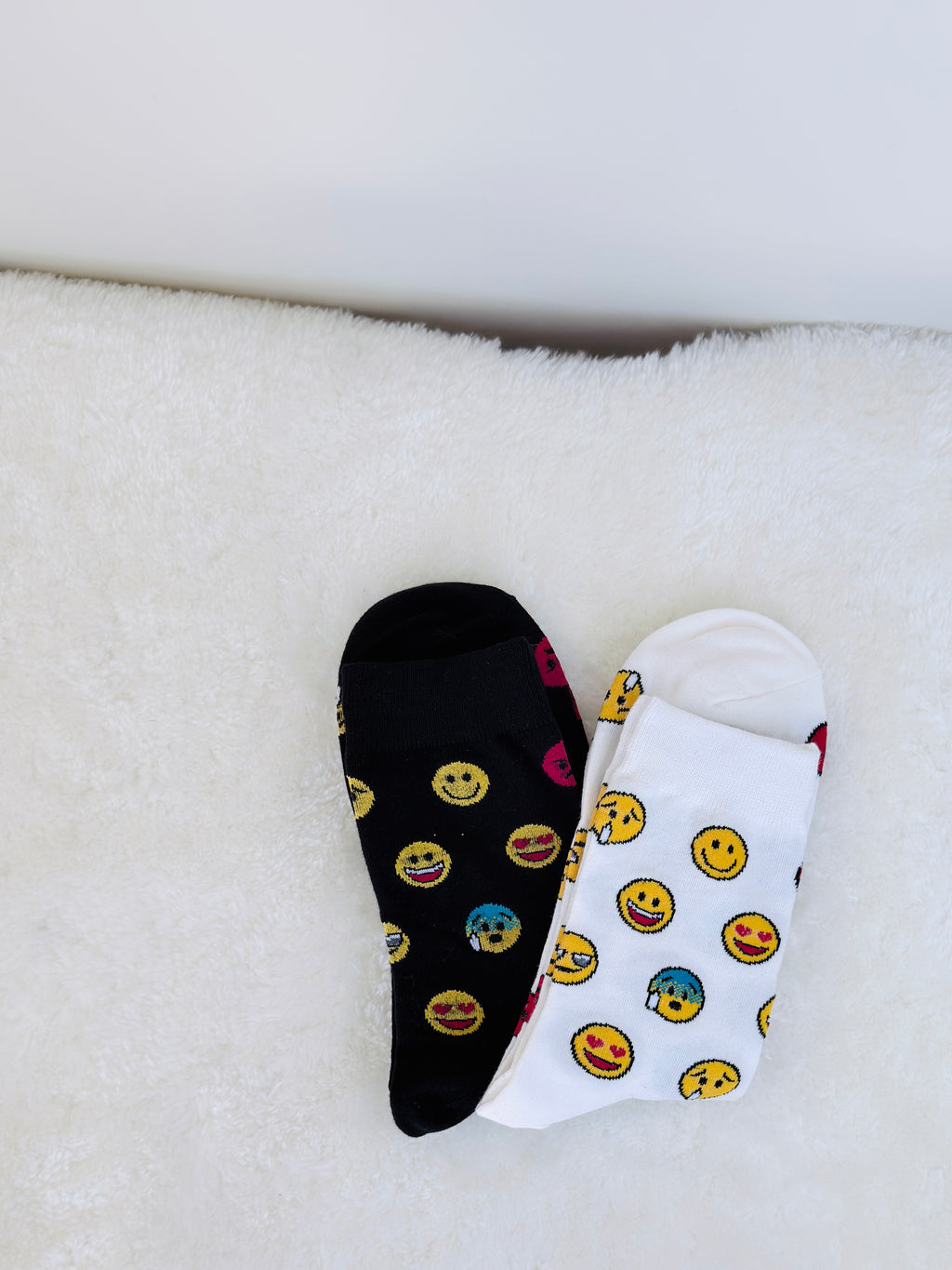 White /black cotton crew socks featuring various expressive yellow emoji faces like smiling, cool with sunglasses, and winking.