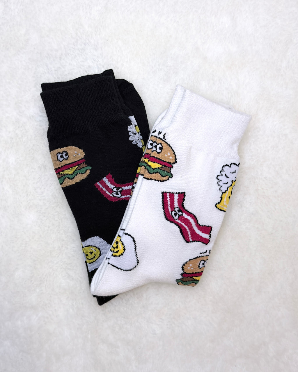 Two pairs of socks with cartoon character designs on a white background