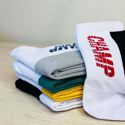 Five pairs of athletic design socks in red, yellow, green, navy, and black with bold CHAMP lettering.