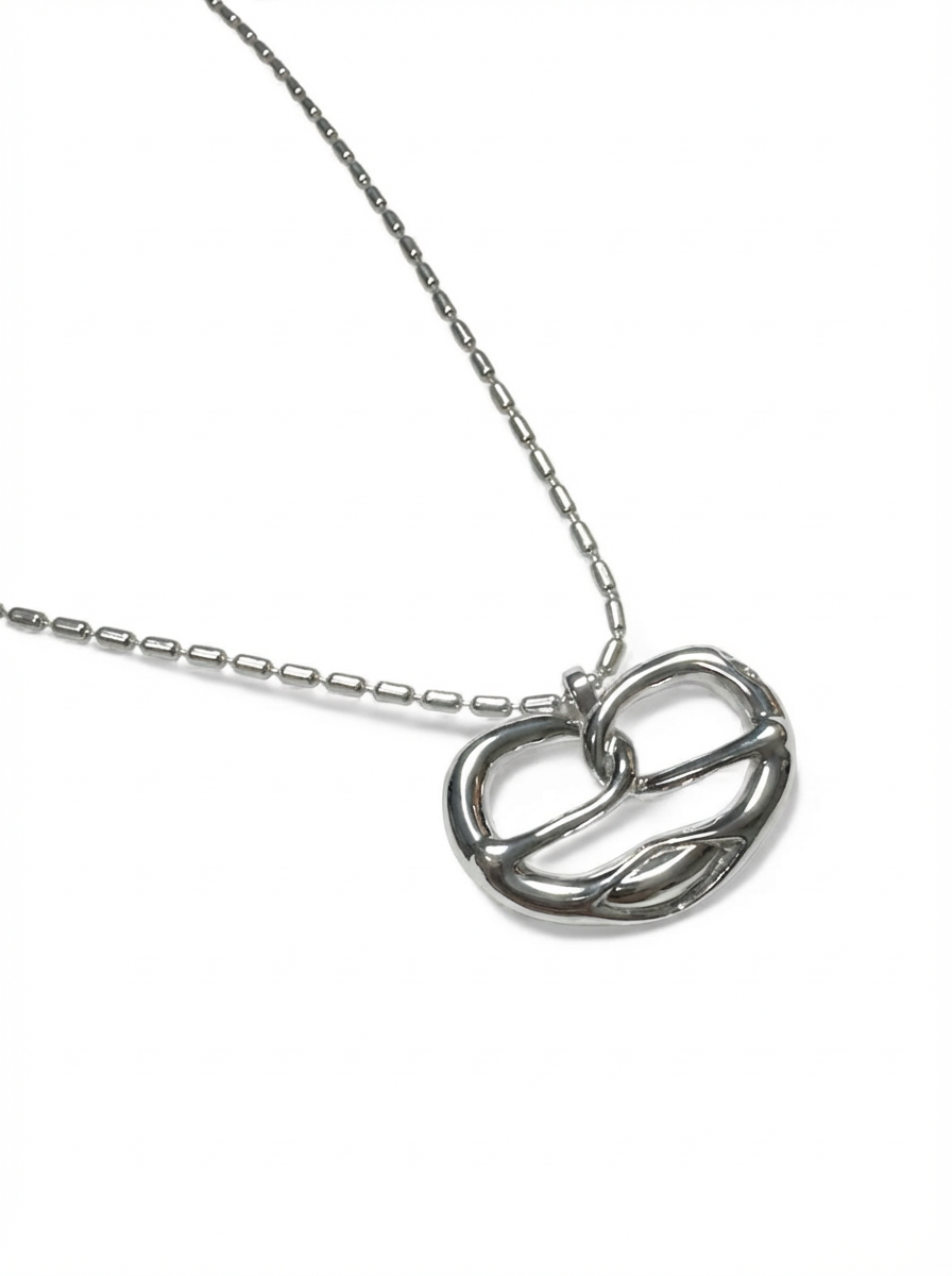 Silver necklace with a pretzel pendant on a white background